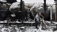 Tampak pekerja membersihkan area depo yang terbakar.  