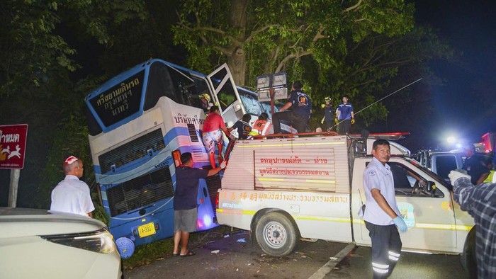 In this photo provided by Sawang Rungrueang Rescue22 Foundation, rescue workers and volunteers rescue an injured passenger at the site of a bus accident Tuesday, Dec 5, 2023, at the Prachuap Khiri Khan province, Thailand.  A dozen of people were killed after the vehicle fell off the road and hit a big tree.(Sawang Rungrueang Rescue22 Foundation via AP)