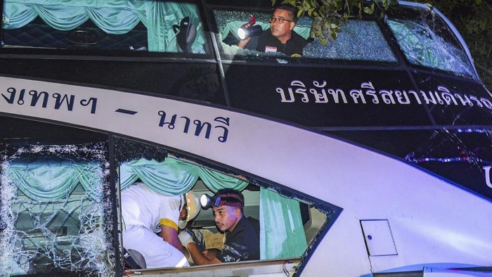 In this photo provided by Sawang Rungrueang Rescue22 Foundation, rescue workers and volunteers rescue an injured passenger at the site of a bus accident Tuesday, Dec 5, 2023, at the Prachuap Khiri Khan province, Thailand.  A dozen of people were killed after the vehicle fell off the road and hit a big tree.(Sawang Rungrueang Rescue22 Foundation via AP)