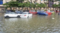 Di Chennai, ibu kota Tamil Nadu, warga berjuang menghadapi banjir setinggi pinggang yang juga merendam mobil.