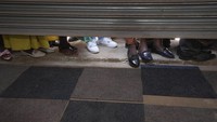 Warga berdiri di luar pintu masuk bursa kerja pemerintah, di Harare, Zimbabwe, Rabu (6/12/2023).