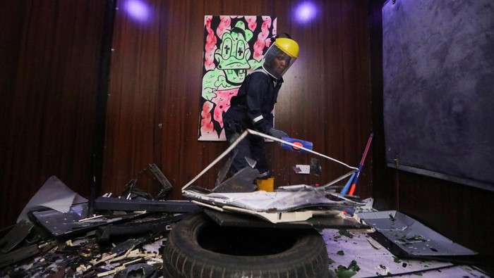 People smash a musical keyboard at the Shadow rage room, a place where people can destroy objects to vent anger, in Lagos, Nigeria October 15, 2023. REUTERS/Temilade Adelaja