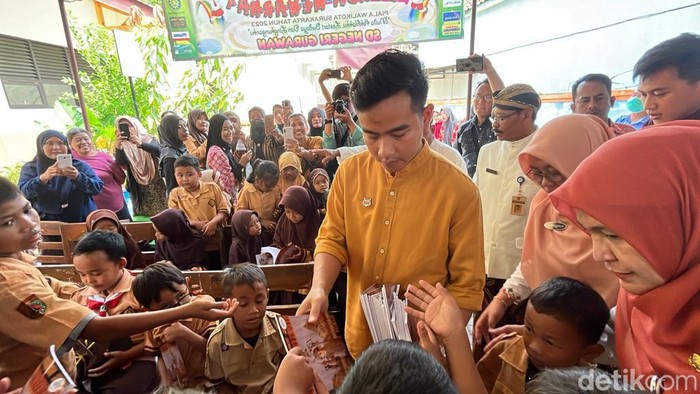 Wali Kota Solo Gibran Rakabuming Raka membagikan susu kotak dan buku di SDN Gurawan, Solo, Kamis (7/12/2023).