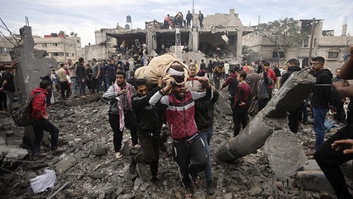 Palestinians evacuate a wounded woman following Israeli airstrikes in Khan Younis refugee camp, southern Gaza Strip, Thursday, Dec. 7, 2023. (AP Photo/Mohammed Dahman)