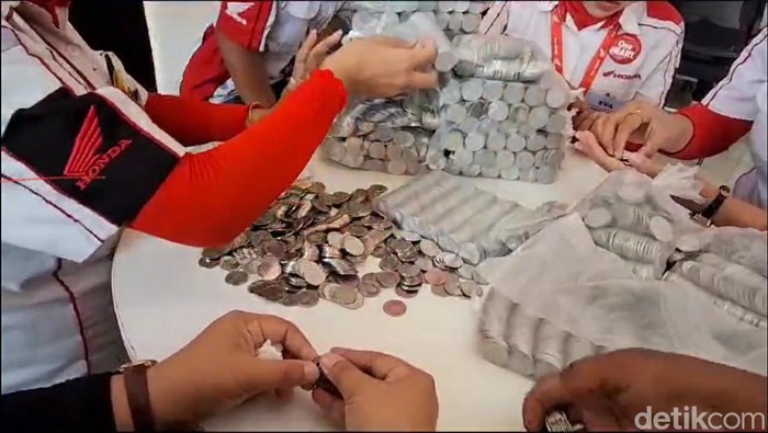 Dealer di Naga Mas Tegal menghitung uang receh yang dibawa Nadiah Yasmin, seorang guru honorer yang membayar motor secara tunai menggunakan uang receh.