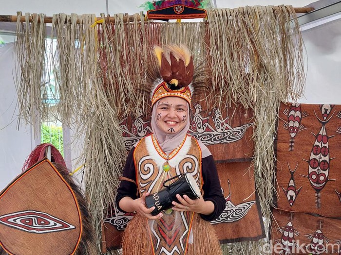 Berfoto dengan baju khas Papua
