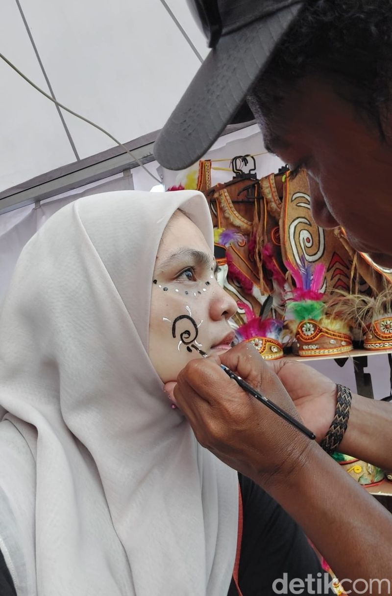 Berfoto dengan baju khas Papua