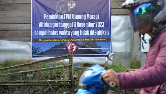 Warga melintas di depan tanda penutupan jalur pendakian Gunung Marapi di Nagari Batu Palano, Agam, Sumatera Barat, Jumat (8/12/2023). Balai Konservasi Sumber Daya Alam (BKSDA) Sumatera Barat selaku pengelola menutup jalur pendakian Taman Wisata Alam (TWA) Gunung Marapi pasca erupsi pada Minggu (3/12) hingga waktu yang tidak ditentukan.  ANTARA FOTO/Iggoy el Fitra/Spt.
