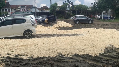 Seorang pekerja tengah menguruk lapangan Ubud, Jumat (8/12/2023). Lapangan tersebut becek dan dikeluhkan wisatawan.
