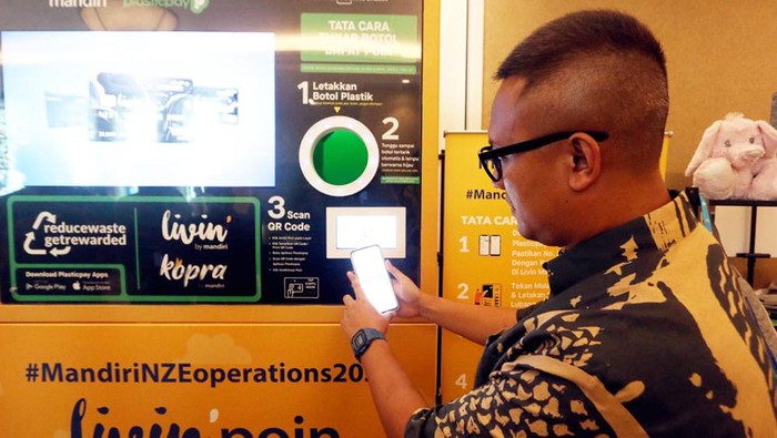 Wakil Direktur Utama Bank Mandiri Alexandra Askandar dan Kepala Ekonom Bank Mandiri Andry Asmoro saat memasukkan botol ke mesin daur ulang botol Plastik di sela perhelatan Mandiri Sustainability Forum di Jakarta, Kamis (7/12/2023).