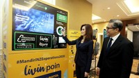 Wakil Direktur Utama Bank Mandiri Alexandra Askandar dan Kepala Ekonom Bank Mandiri Andry Asmoro memasukkan botol ke mesin daur ulang di sela perhelatan Mandiri Sustainability Forum (MSF) di Jakarta, Kamis (7/12/2023).