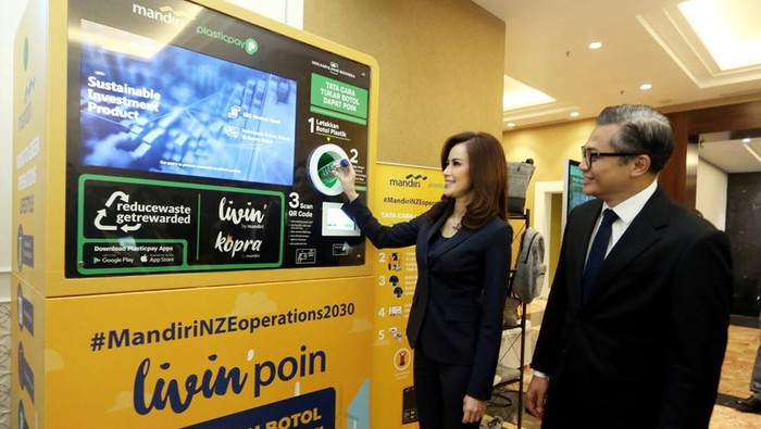 Wakil Direktur Utama Bank Mandiri Alexandra Askandar dan Kepala Ekonom Bank Mandiri Andry Asmoro saat memasukkan botol ke mesin daur ulang botol Plastik di sela perhelatan Mandiri Sustainability Forum di Jakarta, Kamis (7/12/2023).