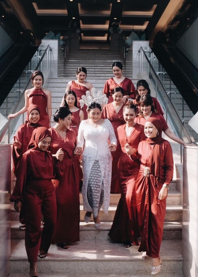 Untuk acara siang hari, bintang serial ‘Teluh Darah’ ini mengenakan gaun warna burgundi berpotongan mermaid.  Foto: Instagram/@miktambayong @bagusboker