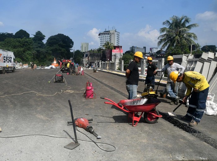 Sejumlah pekerja menyelesaikan proyek pembangunan jembatan Otto Iskandardinata (Otista) di Kota Bogor, Jawa Barat, Kamis (7/12/2023). Pembangunan jembatan Otista yang menggunakan anggaran dari bantuan Pemerintah Provinsi Jawa Barat sebesar Rp52,6 miliar dan menjadi jalan penghubung menuju Istana Kepresidenan Bogor tersebut telah memasuki tahap akhir yang mencapai 96 persen dengan target selesai pada pertengahan Desember 2023. ANTARA FOTO/Arif Firmansyah/nym.