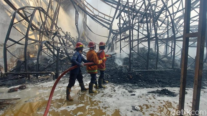 Proses pemadaman kebakaran di gudang logistik Sidoarjo.