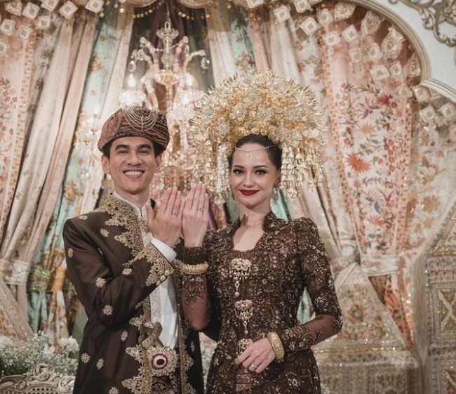 Selanjutnya ada Enzy Storia yang menikah dengan Maulana Kasetra atau biasa dipanggil Molen memakai suntiang. Kali ini Enzy Storia mengenakan kebaya warna cokelat dengan suntiang keemasan. Foto: Instagram @enzystoria