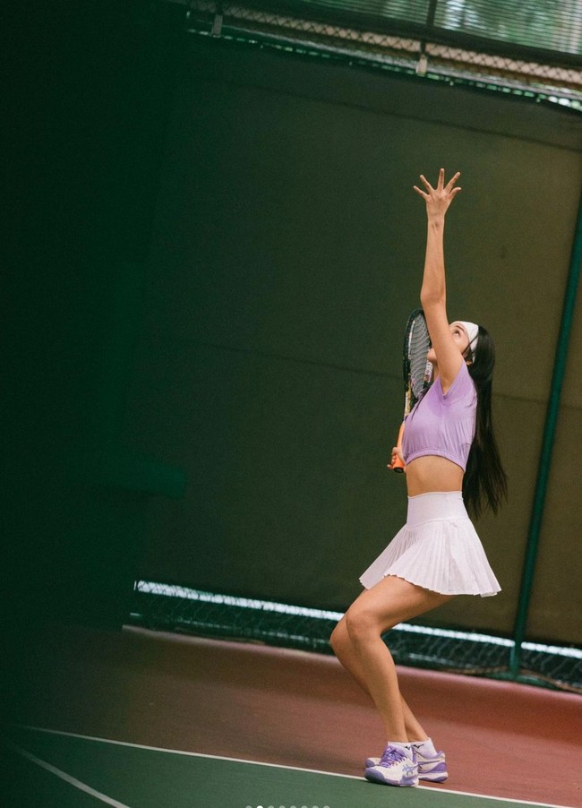 Anya tampil cantik dan seksi mengenakan setelan olahraga berupa atasan crop top berwarna ungu dan rok pendek putih. Penampilannya itu kemudian dilengkapi dengan headband berwarna putih dan sepatu senada dengan pakaian yang dikenakannya. Foto: Instagram/@anyageraldine