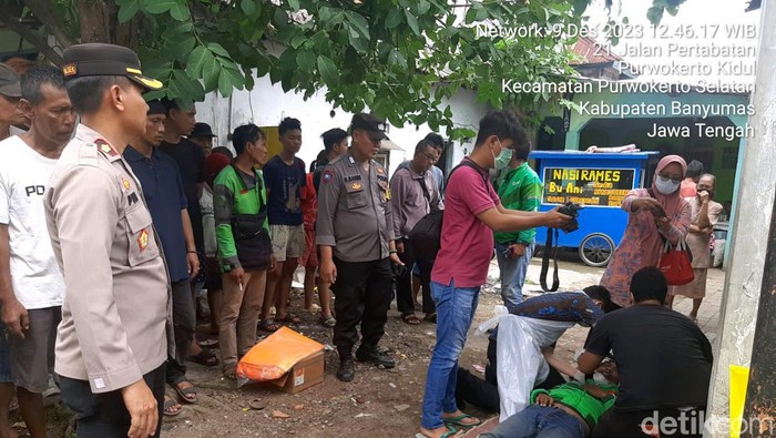 Petugas memeriksa kondisi pengemudi ojol yang ditemukan meninggal dunia saat akan mengantar orderan di Jalan Pertabatan II RT 4 RW 1 Kelurahan Purwokerto Kidul, Kecamatan Purwokerto Selatan, Kabupaten Banyumas, Sabtu (9/12/2023).