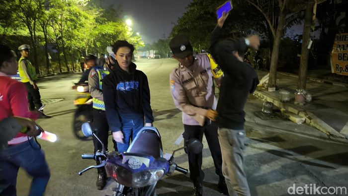 Polisi saat memeriksa pengendara yang terjaring razia di Surabaya.