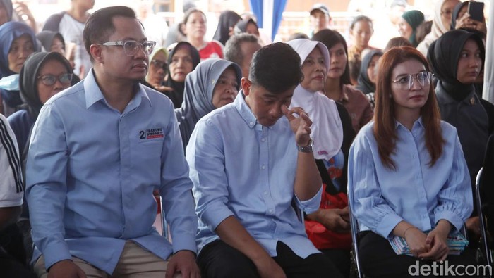 Calon wakil presiden nomor urut 2 Gibran Rakabuming Raka didampingi istri menyapa warga saat kampanye blusukan di kawasan Cempaka Putih Barat,  Jakarta Pusat, Sabtu (9/12/2023). Dalam kesempatan itu Gibran membagikan buku serta mensosialisasikan program kerja jika terpilih menjadi cawapres pada Pemilu 2024.