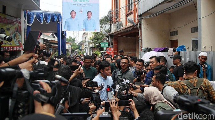 Calon wakil presiden nomor urut 2 Gibran Rakabuming Raka didampingi istri menyapa warga saat kampanye blusukan di kawasan Cempaka Putih Barat,  Jakarta Pusat, Sabtu (9/12/2023). Dalam kesempatan itu Gibran membagikan buku serta mensosialisasikan program kerja jika terpilih menjadi cawapres pada Pemilu 2024.