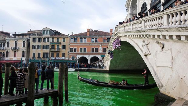 People ride in boats as waters of Grand Canal turned green after a protest by 'Extinction Rebellion' climate activists in Venice, Italy, December 9, 2023. REUTERS/Manuel Silvestri