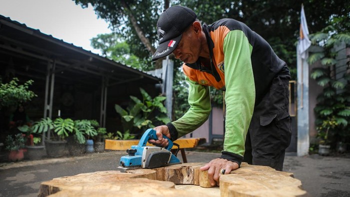 Petugas menyelesaikan pembuatan furnitur dari limbah kayu di Posko UPS Badan Air Pasar Minggu, Jakarta, Minggu (10/12/2023). UPS Badan Air Kecamatan Pasar Minggu memanfaatkan limbah kayu dari Sungai Ciliwung tersebut menjadi furnitur yang memiliki nilai jual. ANTARA FOTO/Asprilla Dwi Adha/foc.