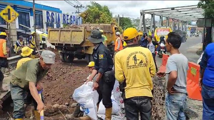 Petugas tengah memperbaiki oprit Jembatan Cikunir, Kabupaten Tasikmalaya.