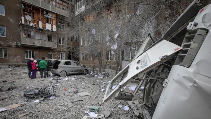 Rudal Rusia Hantam Kharkiv, 7 Blok Apartemen Rusak Local residents stand near their apartment building and cars damaged during a Russian missile strike, amid Russia's attack on Ukraine, in Kharkiv, Ukraine December 8, 2023. REUTERS/Vyacheslav Madiyevskyy TPX IMAGES OF THE DAY