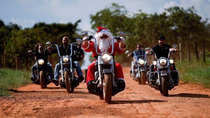 Aksi Sinterklas Naik Moge Bagi-bagi Hadiah Natal di Sekolah Brasil A motorcyclist, Helton Garcia dressed as Santa Claus, rides his motorcycle before handing out gifts to children in a rural school in Santo Antonio do Descoberto, state of Goias, Brazil December 10, 2023. REUTERS/Adriano Machado TPX IMAGES OF THE DAY