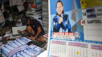 Pekerja menyelesaikan produksi kalender bergambar salah satu calon legislatif dalam Pemilu 2024 di sentra percetakan Bungur, Senen, Jakarta, Senin (11/12/2023).