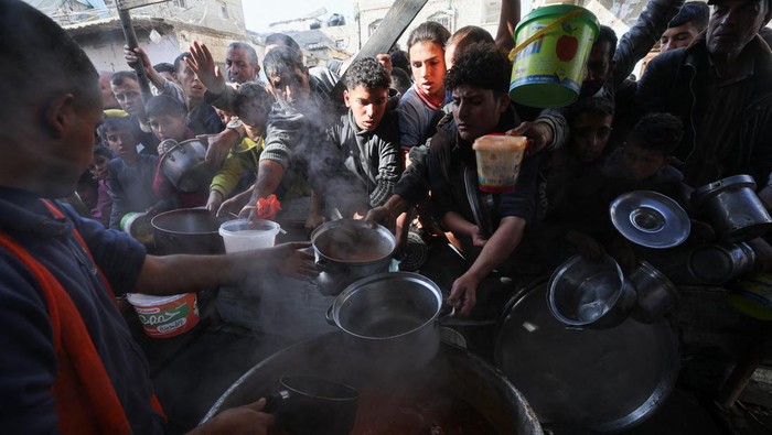 Jerit Warga Gaza Menahan Lapar Berebut Makanan di Tengah Perang A Palestinian child reacts, while people gather to get their share of charity food offered by volunteers, amid food shortages, as the conflict between Israel and the Palestinian Islamist group Hamas continues, in Rafah, in the southern Gaza Strip, December 2, 2023. REUTERS/Ibraheem Abu Mustafa