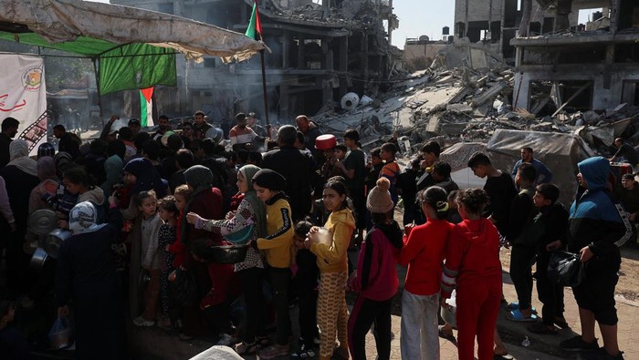 Jerit Warga Gaza Menahan Lapar Berebut Makanan di Tengah Perang A Palestinian child reacts, while people gather to get their share of charity food offered by volunteers, amid food shortages, as the conflict between Israel and the Palestinian Islamist group Hamas continues, in Rafah, in the southern Gaza Strip, December 2, 2023. REUTERS/Ibraheem Abu Mustafa