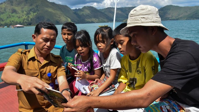 Sejumlah anak pengungsi korban longsor mengikuti kegiatan belajar di atas kapal belajar Alusi Tao Toba di Dermaga Desa Simangulampe, Humbang Hasundutan, Sumatera Utara, Senin (11/12/2023). Kapal belajar yang digunakan sejak tahun 2015 itu memiliki koleksi buku sebanyak 1.000 buku, berkeliling ke tujuh kabupaten di seputaran Danau Toba guna mencerdaskan anak dan menjaga minat baca sejak usia dini. ANTARA FOTO/Fransisco Carolio/Spt.