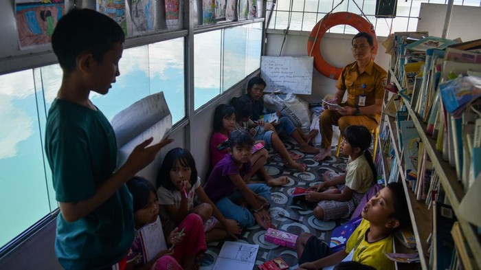 Sejumlah anak pengungsi korban longsor mengikuti kegiatan belajar di atas kapal belajar Alusi Tao Toba di Dermaga Desa Simangulampe, Humbang Hasundutan, Sumatera Utara, Senin (11/12/2023). Kapal belajar yang digunakan sejak tahun 2015 itu memiliki koleksi buku sebanyak 1.000 buku, berkeliling ke tujuh kabupaten di seputaran Danau Toba guna mencerdaskan anak dan menjaga minat baca sejak usia dini. ANTARA FOTO/Fransisco Carolio/Spt.