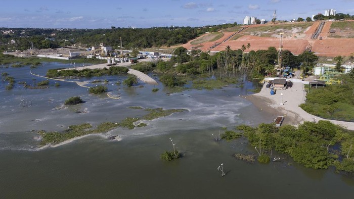 Penampakan Pecahnya Tambang Garam Batuan di Brasil A view of sunken ground at the Mutange neighborhood in Maceio, Alagoas state, Brazil, Sunday, Dec. 10, 2023. A closed rock salt mine owned by the Brazilian petrochemical company Braskem partially collapsed in an area that had previously been evacuated, according to the city’s civil defense authority. (AP Photo/Itawi Albuquerque)