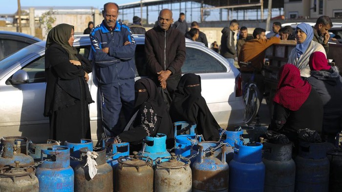 Palestinias line up for cooking gas during the ongoing Israeli bombardment of the Gaza Strip in Rafah on Sunday, Dec. 10, 2023. (AP Photo/Hatem Ali)