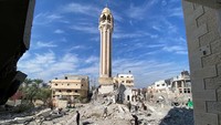 Warga berada di reruntuhan Masjid Othman bin Qashqar yang hancur dihantam serangan bom Israel di Gaza, Palestina.  