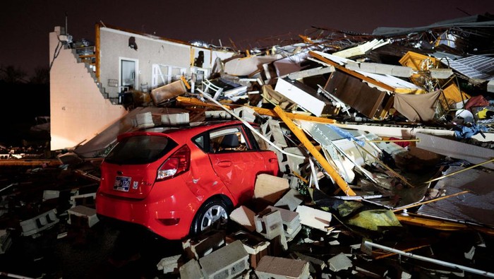 Potret Mobil-mobil Rusak Disapu Tornado Phil Moore checks his vehicle for personal items a day after a tornado hit Madison, Tennessee, U.S. December 10, 2023. REUTERS/Seth Herald