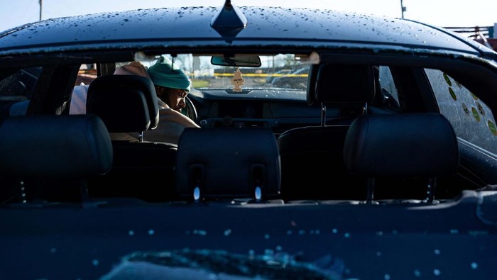 Potret Mobil-mobil Rusak Disapu Tornado Phil Moore checks his vehicle for personal items a day after a tornado hit Madison, Tennessee, U.S. December 10, 2023. REUTERS/Seth Herald