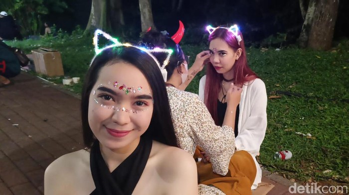 Sejumlah partygoers menempelkan face sticker pada wajahnya sebelum memasuki venue utama festival Djakarta Warehouse Project (DWP) XV di kawasan Garuda Wisnu Kencana (GWK), Bali, Minggu (10/12/2023). (Ni Made Lastri Karsiani Putri/detikBali)