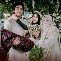 Kemudian ada pula momen ketika Abidzar Al-ghifari menggendong Adiba usai melakukan prosesi siraman. Ia mengenakan baju yang matching dengan Umi Pipik. Foto: Instagram @tw.wedding
