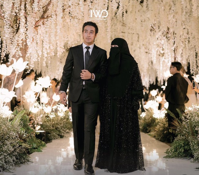 Ketika acara resepsi pernikahan, Abidzar Al-ghifari tampil formal mengenakan setelan jas hitam. Ia berjalan menemani Umi Pipik menemani Abiza Khanza sampai pelaminan. Foto: Instagram @ikeaweddingdream