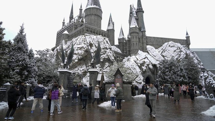 Antusias Warga Beijing Sambut Salju Pertama Musim Dingin In this photo released by Xinhua News Agency, visitors tour near the snow covered Harry Potter castle at the Universal Studios Beijing, Monday, Dec. 11, 2023. An overnight snowfall across much of northern China prompted road closures and the suspension of classes and train service on Monday. (Ren Chao/Xinhua via AP)