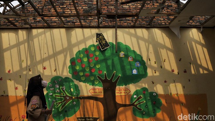 Seorang murid SDN Setiamekar 03 mengamati atap ruang kelas yang roboh di Tambun, Kabupaten Bekasi, Jawa Barat, Selasa (12/12/2023). Menurut pihak sekolah atap dua ruang kelas tersebut roboh pada Jumat (8/12) dan untuk sementara siswa belajar secara bergantian di tiga ruang kelas tersisa dengan dibatasi waktu selama 3 jam. ANTARA FOTO/ Fakhri Hermansyah/rwa.