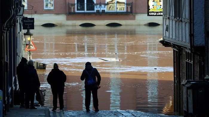 People stand and look at the rising water after the River Ouse burst its banks following heavy rain in York, Britain, December 11, 2023. REUTERS/Phil Noble TPX IMAGES OF THE DAY