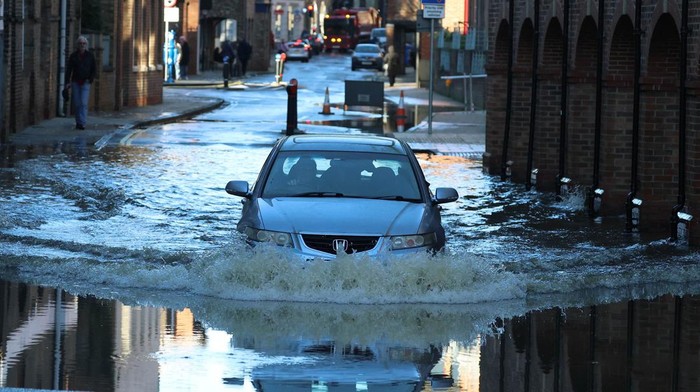 People stand and look at the rising water after the River Ouse burst its banks following heavy rain in York, Britain, December 11, 2023. REUTERS/Phil Noble     TPX IMAGES OF THE DAY