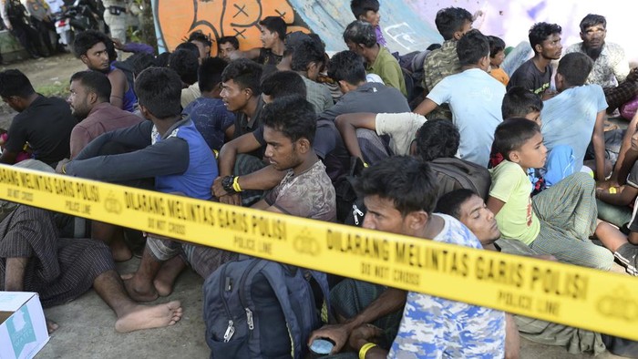 Acehnese men block the entrance gate to a temporary shelter to prevent Rohingya refugees from entering in Ladong, Aceh province, Indonesia, Monday, Dec. 11, 2023. Two boats carrying hundreds of Rohingya Muslims, including emaciated women and children, arrived on Sunday at Indonesias northernmost province of Aceh where they faced rejection from local communities who are protesting against the increasing numbers of refugees that have entered the region over the past few weeks. (AP Photo/Reza Saifullah)