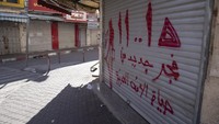 Tulisan dalam bahasa Arab berbunyi fajar baru dalam kehidupan bangsa Arab. terlihat di toko yang tutup.  