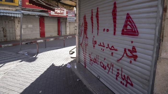 Pusat Komersil Palestina di Tepi Barat Tutup Sebagai Solidaritas ke Gaza Palestinian shops are closed during a general strike in solidarity with Gaza at the commercial center of the West Bank city of Ramallah, Monday, Dec. 11, 2023. Arabic reads